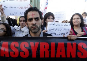 Assyrians hold banners as they march in solidarity with the Assyrians abducted by Islamic State fighters in Syria earlier this week, in Beirut
