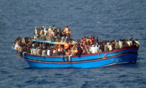In this photo released by the Italian Navy on Monday, June 30, 2014, and taken on Sunday, June 29, 2014, a boat overcrowded with migrants is pictured in the Mediterranean Sea. The bodies of some 30 would-be migrants were found in in the hold of a packed smugglers' boat making its way to Italy, the Italian navy said Monday. The boat was carrying nearly 600 people, and the remaining 566 survivors were rescued by the navy frigate Grecale and were headed to the port at Pozzallo, on the southern tip of Sicily. (AP Photo/Italian Navy, ho)