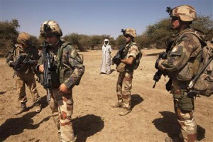 French soldiers stand guard next to a local resident outside Gao, Mali, March 9 2013. Picture taken March 9, 2013. REUTERS/Emmanuel Braun