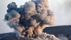 Smoke rises from the impact of an airstrike next to the hill where Islamic State (IS) militants had placed their flag in the Syrian town of Ain al-Arab, known as Kobane by the Kurds, seen  from the Turkish-Syrian border in the southeastern village of Mursitpinar, Sanliurfa province, on October 8, 2014. The Pentagon warned on October 8, 2014 US air power on its own could not prevent Islamic State jihadists from capturing the Syrian border town of Kobane, even as US warplanes kept up bombing raids in the area. AFP PHOTO / ARIS MESSINIS        (Photo credit should read ARIS MESSINIS/AFP/Getty Images)