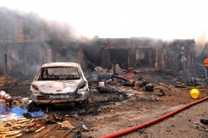 The wreckage of a charred vehicle remains in front of burning shops following a bomb blast at Terminus market in the central city of Jos on May 20, 2014. Twin car bombings on Tuesday killed at least 46 in central Nigeria in the latest in a series of deadly blasts that will stoke fears about security despite international help in the fight against Boko Haram Islamists. AFP PHOTO / STRSTR/AFP/Getty Images