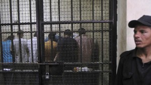 Defendants accused of mob sexual assaults stand behind bars at a court in Cairo June 25, 2014. A Cairo court opened on Wednesday a trial against 13 men in connection with mob sexual assaults on women during public rallies, which have caused public outrage in the conservative Arab counrtry. The men are being charged in five separate cases involving nine women who were attacked, stripped of their clothing, sexually assaulted and beaten by gangs of men at rallies in and around the Tahrir Square area where the 2011 uprising began. REUTERS/Al Youm Al Saabi Newspaper (EGYPT - Tags: CIVIL UNREST CRIME LAW) EGYPT OUT. NO COMMERCIAL OR EDITORIAL SALES IN EGYPT