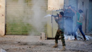 FILE - In this Wednesday, Oct. 29, 2014 file photo, Libyan military soldiers fire their weapons during clashes with Islamic militias in Benghazi. Libya, virtually a failed state the past years, has provided a perfect opportunity for the Islamic State group to expand from its heartland of Syria and Iraq to establish a strategic stronghold close to European shores. (AP Photo/Mohammed El-Sheikhy, File)