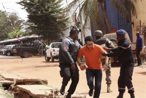 FILE - In this Nov. 20, 2015 file photo, Mali troopers assist a hostage, center, to leave the scene, from the Radisson Blu hotel to safety after gunmen attacked the hotel in Bamako, Mali. The murders of Chinese citizens by Islamic militants in Syria and Mali place President Xi Jinping in a quandary: How can Beijing respond effectively without betraying its strict stance against intervention? The dilemma underscores the tension between Chinas desire to be seen as a leading global power and its desire to remain independent whiling shunning the U.S.-led Western political agenda. (AP Photo/Harouna Traore, File)