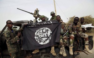 Nigerien soldiers hold up a Boko Haram flag that they had seized in the recently retaken town of Damasak, Nigeria, March 18, 2015. Chadian and Nigerien soldiers took the town from Boko Haram militants earlier this week. The Nigerian army said on Tuesday it had repelled Boko Haram from all but three local government districts in the northeast, claiming victory for its offensive against the Islamist insurgents less than two weeks before a presidential election. Picture taken March 18.    REUTERS/Emmanuel Braun (NIGERIA - Tags: VIOLENCE CONFLICT MILITARY)            TPX IMAGES OF THE DAY            TPX IMAGES OF THE DAY