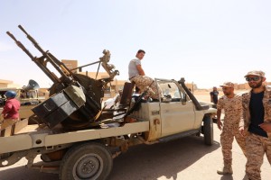 EDITORS NOTE: Graphic content / Libyan pro-government forces walk next to their vehicle mounted with a machine gun on May 18, 2016 in Abu Grein, south of Libya's third city Misrata, a day after Libya's unity government recaptured the area from the Islamic State (IS) group. four of the Bodies of The organization of the Islamic State (Daash) in a truck in Abu Qurayn About 300 km east of the Libyan capital Tripoli , on May 18, 2016. The UN-backed Government of National Accord (GNA) forces said on Facebook that they recaptured  Abu Grein strategic crossroads, where the coastal highway meets the main road south into the desert interior on May 17, 2016.  / AFP PHOTO / MAHMUD TURKIA