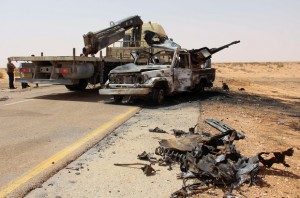 A truck removes the remains of a burnt-out vehicle following a car bomb attack on a security post in the Saddada area near the eastern Libyan city of Misrata on April 13, 2016.   Local government and medical sources reported the attack left one dead and four in a serious condition. / AFP PHOTO / STRINGER