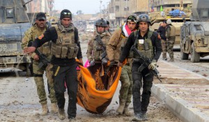 Iraqi government forces and members of Iraq's elite counter-terrorism service carry the body of a comrade during battles with Islamic State (IS) group jihadists as they try to secure all the neighbourhoods of Ramadi, the capital of Iraq's Anbar province, about 110 kilometers west of the capital Baghdad, on January 1, 2016.  Iraq declared the city of Ramadi liberated from the Islamic State group on December 28 and raised the national flag over its government complex after clinching a landmark victory against the jihadists. AFP PHOTO / STR / AFP / STR        (Photo credit should read STR/AFP/Getty Images)