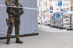 An armed soldier stands behind a cordon in central Brussels on July 20, 2016, during a police intervention to surround a "suspect" individual. Police backed by bomb disposal teams on July 20 cordoned off part of central Brussels where they surrounded a "suspect" individual wearing a long coat with wires showing. "Following police intervention, a cordon has been established" around part of the Place de la Monnaie and adjoining streets, Brussels police said in a tweeted message. / AFP / Belga / SISKA GREMMELPREZ / Belgium OUT        (Photo credit should read SISKA GREMMELPREZ/AFP/Getty Images)