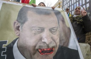 Kurdish people display a picture of Turkish President Tayyip Erdogan during a protest outside an EU-Turkey summit as the bloc is looking to Ankara to help it curb the influx of refugees and migrants flowing into Europe, in Brussels March 7, 2016. REUTERS/Yves Herman      TPX IMAGES OF THE DAY - RTS9N0A