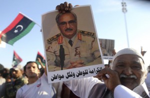 A man holds a picture of General Khalifa Haftar during a demonstration in support of "Operation Dignity" in Benghazi May 23, 2014. Libyan renegade general Khalifa Haftar called on the government to hand over power to the country's top judges, mounting a challenge against Tripoli as heavy fighting erupted in the capital on Wednesday. Western powers fear a call by Haftar for army units to join "Operation Dignity", his campaign against Islamists, will split the nascent military and trigger more turmoil in the country. REUTERS/Esam Omran Al-Fetori (LIBYA - Tags: POLITICS CIVIL UNREST) - RTR3QLHI